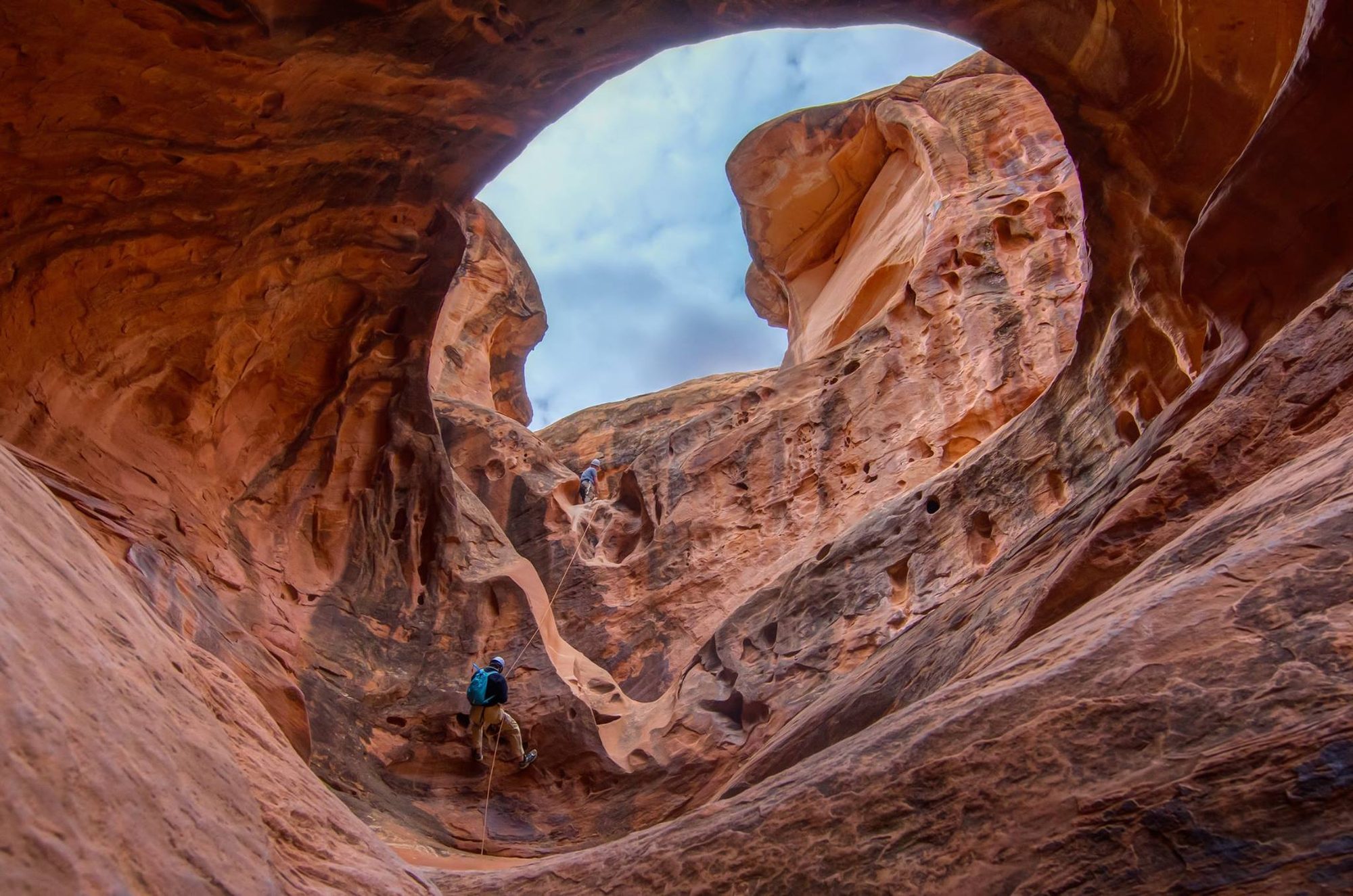 A guide leading a rappel into a Moab slot canyon with NAVTEC