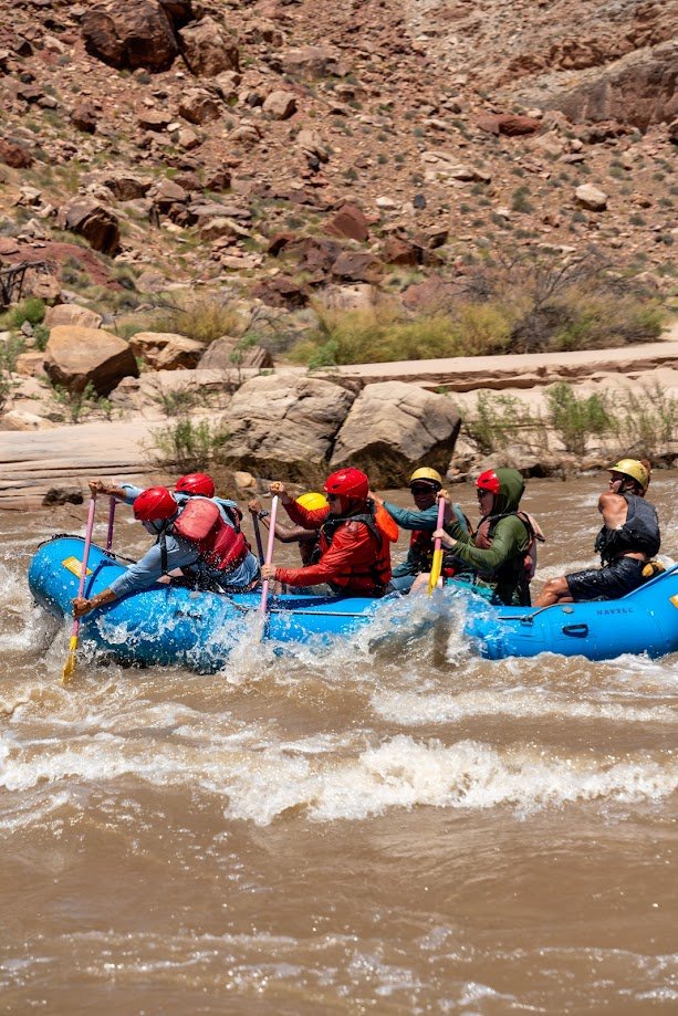 A NAVTEC paddle raft of guests splashing through the Colorado River near Moab