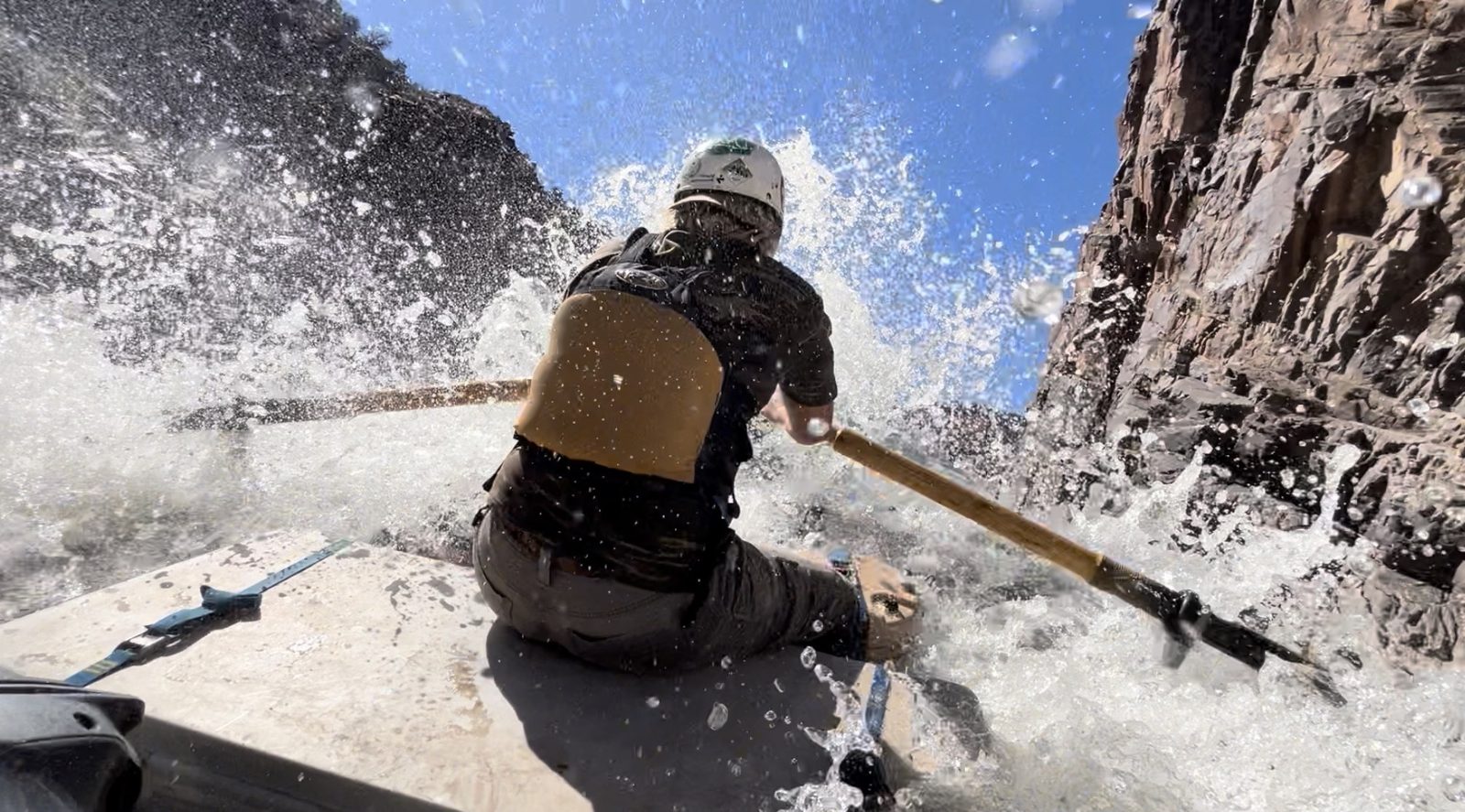 Guide rowing through a whitewater wave on the Colorado River